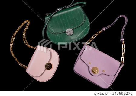 Three womens leather handbags set in green pink and lilac isolated on black background Three womens leather handbags set in green pink and lilac isolated on black background 143699276