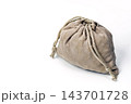 Conceptual photo of a tightly closed beige suede drawstring pouch bag with braided cord, concealing mysterious unknown contents that could be precious valuables or something worthless, isolated 143701728