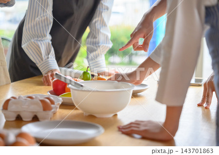 料理教室で食材を指差して調理方法を相談する人々の手元 料理教室で食材を指差して調理方法を相談する人々の手元 143701863