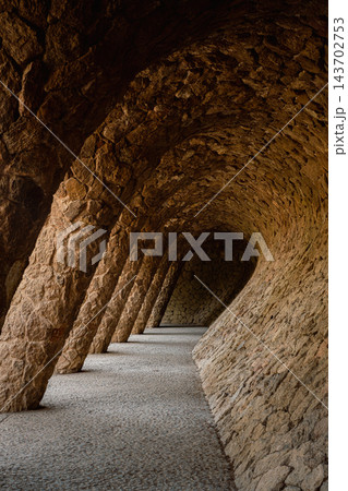 Empty vaulted stone gallery with slanted columns in Park Guell Barcelona 143702753