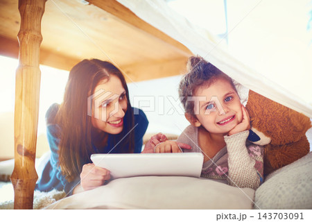 Home, mother and girl with tablet, smile and social media with happiness, bonding together and relax. Family, parent and mama with daughter, tech and digital app for cartoon film, online game or love 143703091