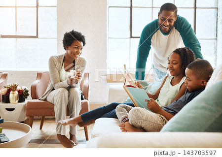 Black family, reading book and children on couch in home, care and learning for language with smile. African parents, people and storytelling for connection, bonding and relax in pajamas in morning Black family, reading book and children on couch in home, care and learning for language with smile. African parents, people and storytelling for connection, bonding and relax in pajamas in morning 143703597