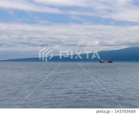 【北海道】利尻島沖を行く小さな船と雲に覆われた山麓 【北海道】利尻島沖を行く小さな船と雲に覆われた山麓 143703689