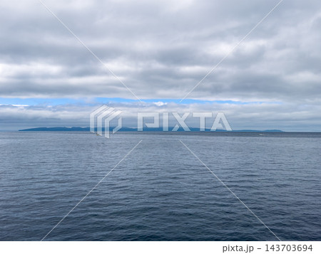 【北海道】日本海に浮かぶ礼文島の島影と小さな漁船 143703694