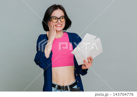 Young woman opening letter gradually smiling more expressing joyful news lottery win test results Young woman opening letter gradually smiling more expressing joyful news lottery win test results 143704776