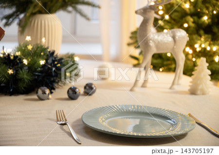 Elegant Christmas table setting with glowing tree lights Elegant Christmas table setting with glowing tree lights 143705197