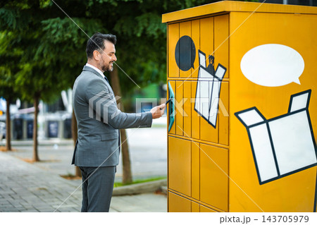 Businessman using smartphone for automated locker parcel pickup 143705979