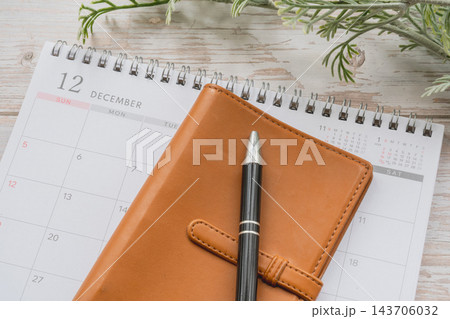 12月のカレンダーと本革の手帳とペンの年末スケジュール管理や振り返りのライフプラン背景素材 12月のカレンダーと本革の手帳とペンの年末スケジュール管理や振り返りのライフプラン背景素材 143706032