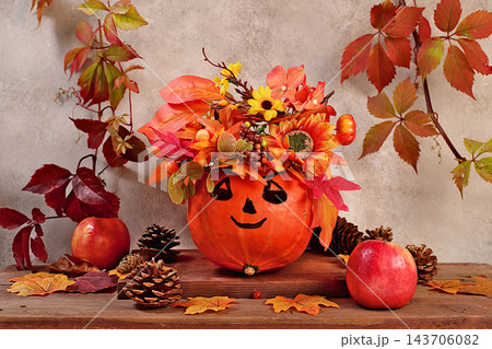 Autumn still life featuring pumpkins adorned with festive leaf wreaths and playful faces with googly eyes, along with apples and rowan berries, all set on an old wooden table, Thanksgiving theme, Autumn still life featuring pumpkins adorned with festive leaf wreaths and playful faces with googly eyes, along with apples and rowan berries, all set on an old wooden table, Thanksgiving theme, 143706082