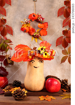 Pumpkins adorned with festive leaf wreaths and playful faces with googly eyes, along with apples and rowan berries, all set on an old wooden table, Thanksgiving theme, rustic harvest, banner Pumpkins adorned with festive leaf wreaths and playful faces with googly eyes, along with apples and rowan berries, all set on an old wooden table, Thanksgiving theme, rustic harvest, banner 143706083