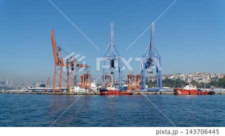 Haydarpasa Port in Kadikoy, Istanbul, Turkey, a cargo port with container cranes, red tugboats along the quay and rows of new cars waiting for shipping Haydarpasa Port in Kadikoy, Istanbul, Turkey, a cargo port with container cranes, red tugboats along the quay and rows of new cars waiting for shipping 143706445
