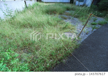 住宅と壁に囲まれた住宅街の狭小な未利用空き地(不動産・住宅地・土地活用イメージ) 住宅と壁に囲まれた住宅街の狭小な未利用空き地(不動産・住宅地・土地活用イメージ) 143707617
