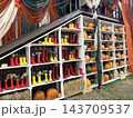Autumn Harvest Display with White Shelves, Pumpkins, and Rubber Boots  143709537