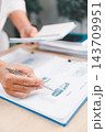 Close-up of a business professional pointing at a pie chart on financial reports with a pen, representing market analysis, budgeting, statistics, accounting, planning, and performance review. 143709951