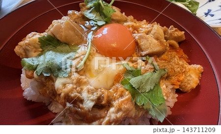 卵黄をのせたとろとろ親子丼と三つ葉 143711209