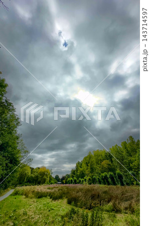 Foreboding weather building over vibrant natural scenery Foreboding weather building over vibrant natural scenery 143714597