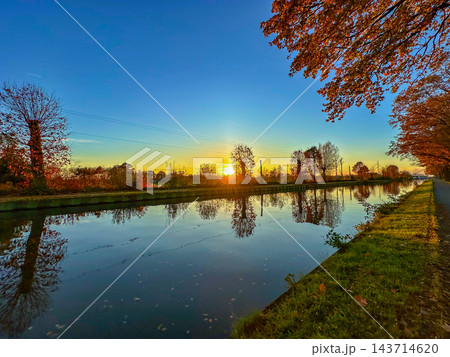 Peaceful river view featuring fall foliage and shimmering water Peaceful river view featuring fall foliage and shimmering water 143714620