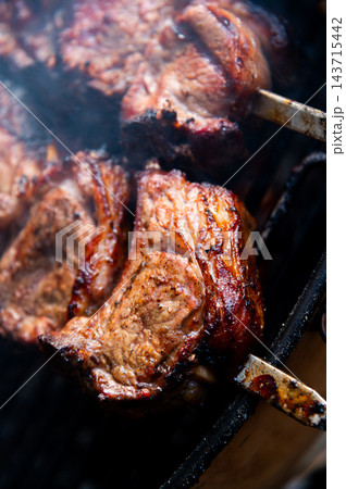 Grilled meat on skewers on a barbecue grill Grilled meat on skewers on a barbecue grill 143715442