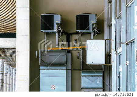 HVAC Air Conditioning Units and Metal Ductwork Mounted on Building Exterior Wall 143715621