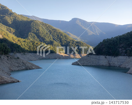 Morning sunlight illuminates the Ridracoli lake and mountain landscape in the Apennines of Italy. 143717530