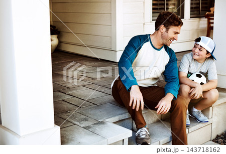 Family, ball and father with child on porch in home ready for playing soccer, sports and fun on weekend. Happy, parents and dad with young boy talking, in conversation and relax outdoors for bonding 143718162