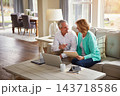 Senior couple, paperwork and finance on sofa with laptop, smile and talk for profit in home. Old man, woman and computer with documents for compliance, audit and investment report for budget review 143718586