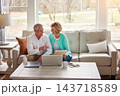 Senior couple, paperwork and laptop on couch with discussion, smile and point for taxes in home. Old man, woman and computer with documents for compliance, reading and investment report with finance 143718589