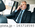 Talking, mature man and phone call in taxi for transport, schedule meeting, communication in backseat. Mobile, vehicle and employee with paperwork for conversation, commute or travel on business trip 143718593