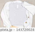 Heather grey folded t-shirt mockup on white knitted cardigan, template for print on demand 143720028