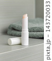 Open lip balm stick with a lid mockup in green bathroom. Herbal cosmetic product for home use 143720033