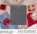Washed grey t-shirt mockup near Christmas decor, folded crewnwck flat lay. Holiday template 143720041