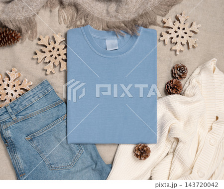 Falded washed light blue t-shirt mockup near rustic Christmas decor, flat lay. Holiday template Falded washed light blue t-shirt mockup near rustic Christmas decor, flat lay. Holiday template 143720042