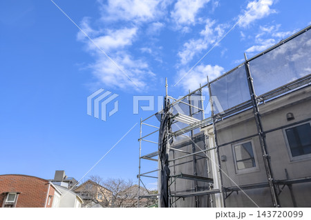 屋根修繕中の住宅と新しい外壁サイディング 屋根修繕中の住宅と新しい外壁サイディング 143720099