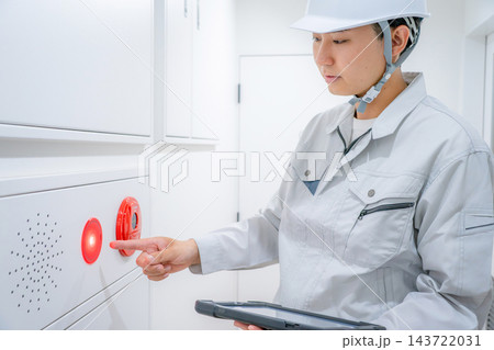 自動火災報知設備の点検をする作業着の男性 自動火災報知設備の点検をする作業着の男性 143722031