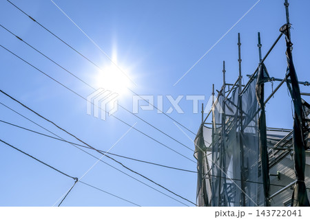 青空と太陽の下に組まれた外壁リフォーム工事の仮設足場 青空と太陽の下に組まれた外壁リフォーム工事の仮設足場 143722041