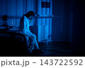 Hospital bed with weary patient. Individual resting on hospital bed illuminated by soft blue glow. Tired patient seated on hospital bed amid shadows and medical instruments Hospital bed with weary patient. Individual resting on hospital bed illuminated by soft blue glow. Tired patient seated on hospital bed amid shadows and medical instruments 143722592