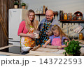 Family smiling while sharing baked treats on kitchen island, laughter and satisfied expressions, jars and cups on counter, cozy lighting and celebratory yet casual atmosphere Family smiling while sharing baked treats on kitchen island, laughter and satisfied expressions, jars and cups on counter, cozy lighting and celebratory yet casual atmosphere 143722593