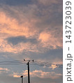 夕暮れ時に電柱で休むカラスたち 143723039