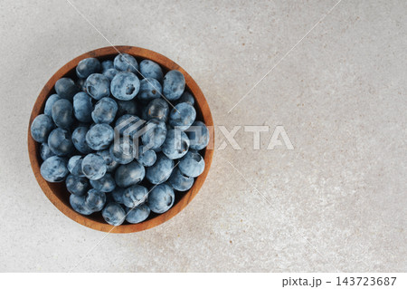 Fresh ripe blueberries in wooden bowl on a light gray textured background. Healthy organic food Fresh ripe blueberries in wooden bowl on a light gray textured background. Healthy organic food 143723687