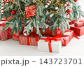 Red wrapped gift boxes, presents under festive Christmas tree with lights and holiday decorations 143723701