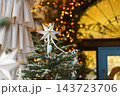 Christmas tree with white star, ornaments and warm fairy lights, festive illuminated background 143723706