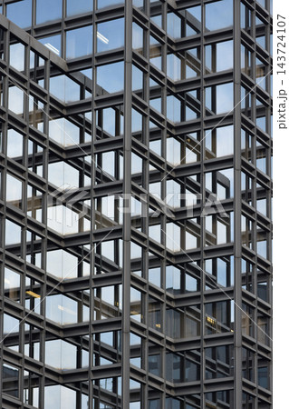A modern multi-story building facade featuring geometric steel lattice and glass. A modern multi-story building facade featuring geometric steel lattice and glass. 143724107