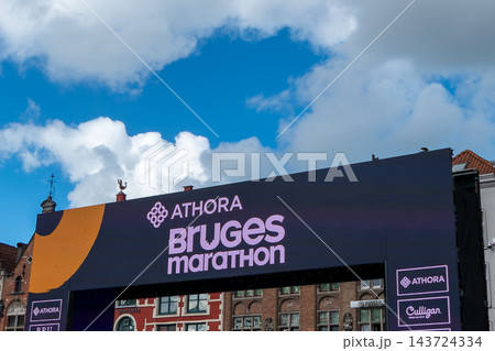 Athora Bruges Marathon finish line arch banner structure against blue sky on Grote Markt in Bruges Belgium 143724334