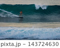 Surfer on a powerful ocean wave, carving across the water with white spray 143724630