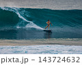 Surfer on a powerful ocean wave, carving across the water with white spray 143724632