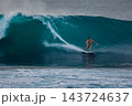 Surfer on a powerful ocean wave, carving across the water with white spray 143724637
