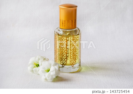 Luxury Arabic Attar Bottle with Gold Pattern on White Fabric 143725454