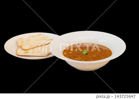 Indian lentil dal soup and flatbreads on white serving plates 143725647
