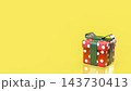 Colorful Red Polka Dot Gift Box with Green Ribbon on Bright Yellow Background 3d render. 143730413