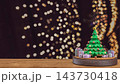 Festive Christmas Tree with Colorful Gift Boxes on Wooden Table and Golden Bokeh Lights Background 3d render. 143730418